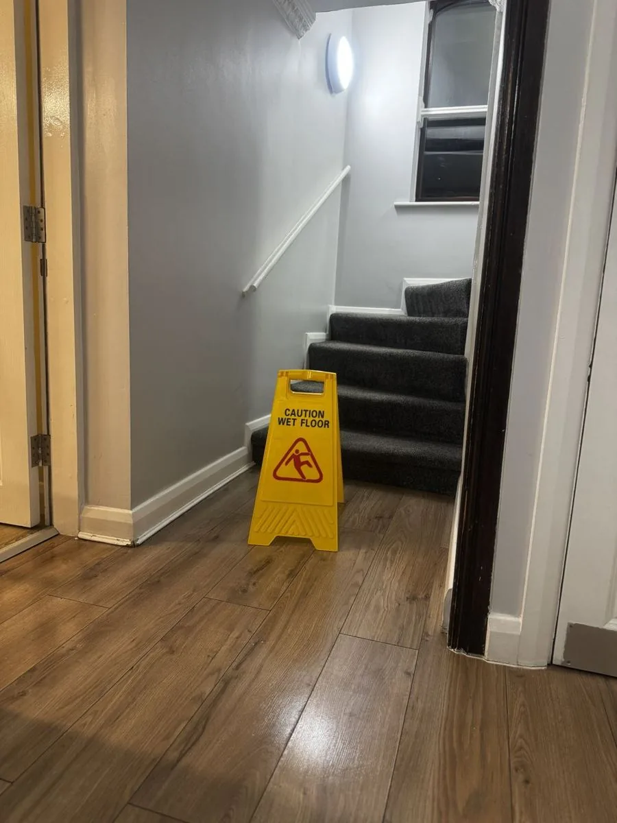 Communal hallway cleaned with wet floor signage