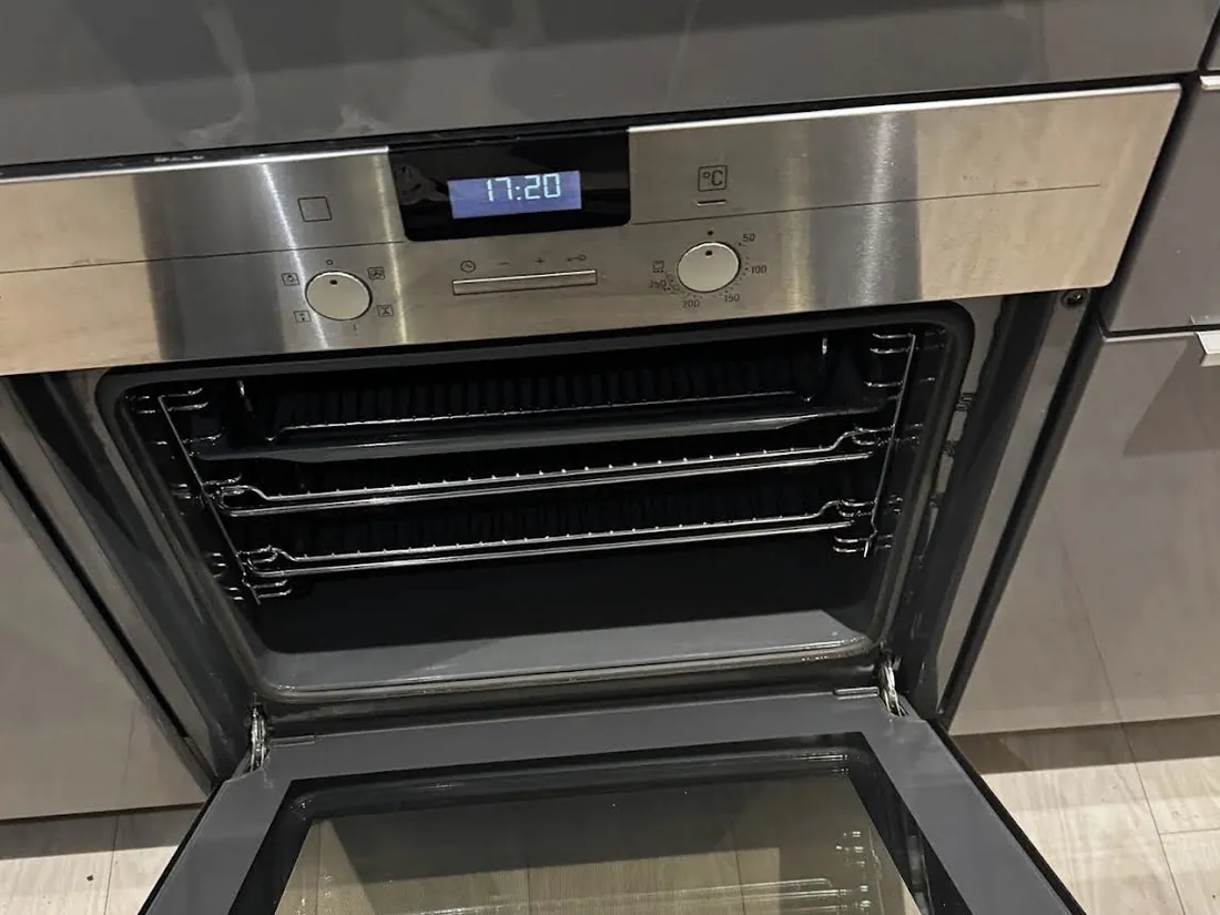 Built-in single oven after cleaning, door open and racks refitted