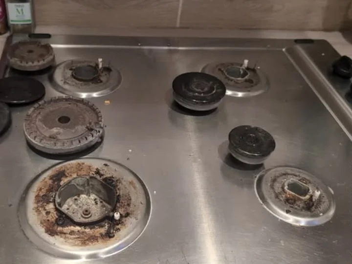Gas hob before cleaning, with burnt-on spillage around the burner bases
