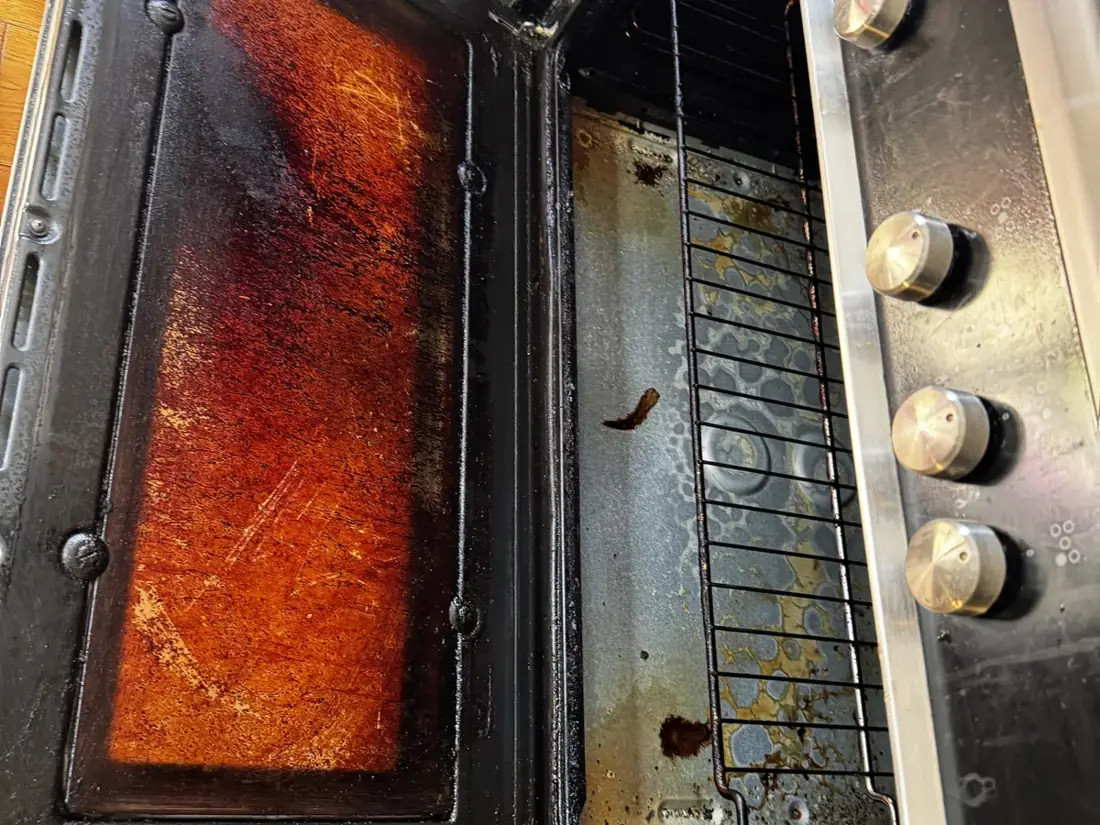 Oven door and interior before cleaning, heavily carbonised